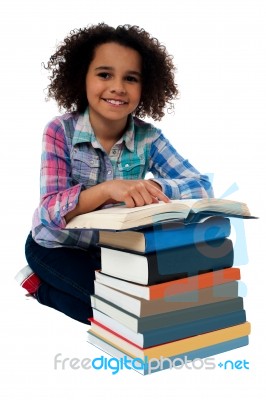 Happy Schoolgirl Reading A Textbook Stock Photo