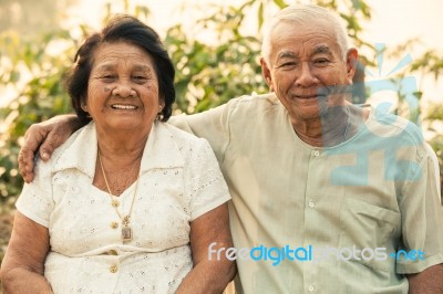 Happy Senior Couple Sitting Outdoors Stock Photo
