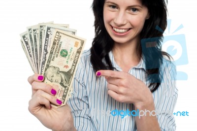 Happy Woman Holdng And Pointing Towards Dollar Notes Stock Photo