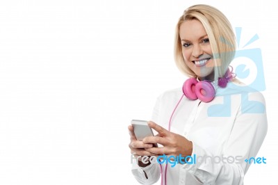 Happy Woman With Cell Phone And Headset Stock Photo