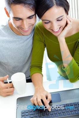 Happy Young Couple Browsing Internet At Home Stock Photo