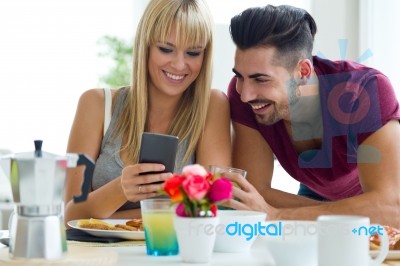 Happy Young Couple Enjoying Breakfast In The Kitchen Stock Photo