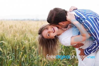 Happy Young Couple Hugging And Kissing Eachother Stock Photo