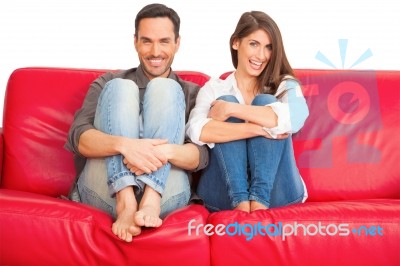 Happy Young Couple Relaxing On Sofa Stock Photo