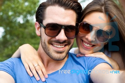 Happy Young Couple Taking Selfies With Her Smartphone In The Par… Stock Photo