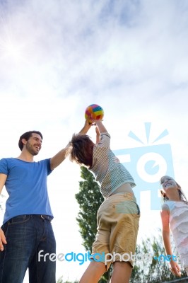 Happy Young Family, Father And Son Playing Ball In The Park Stock Photo
