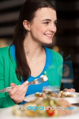 Happy Young Girl Enjoying Her Dinner Stock Photo