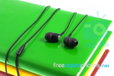 Headphones And Stack Of Multicolored Books On A White Background… Stock Photo
