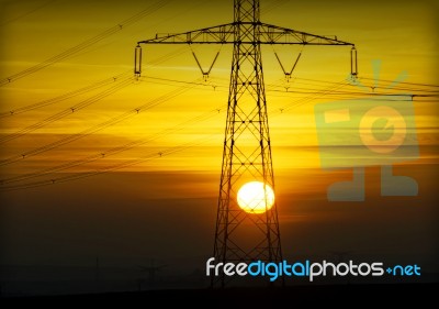 High Voltage Pylons At Sunset Stock Photo