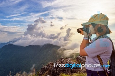 Hiker Taking Photo At Sunset Stock Photo