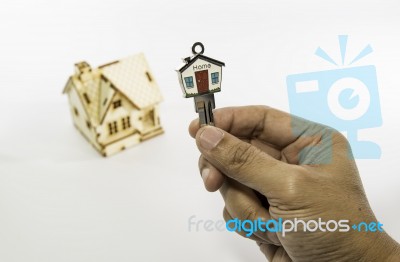 Holding House Key With Small Wooden House Stock Photo