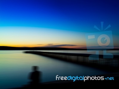 Horizontal Vivid Man's Back Shadow Sitting On The Quay Motion Ab… Stock Photo