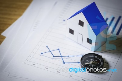 House Model And Compass On Plan Background, Real Estate Concept Stock Photo