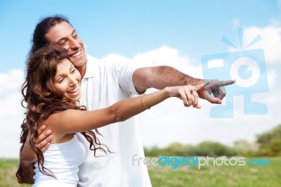 Hugging Couple Pointing Out Stock Photo