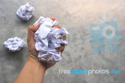 Human Hand Holding Crumpled Paper Ball On Cement Background Stock Photo