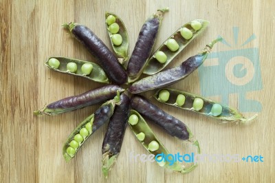 Hybrid Violet Peas In Closeup On A Wooden Background Stock Photo