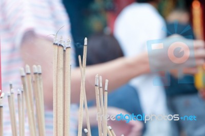 Incense Stick Burning Slowly With Fragrant Smell Smoke. People Praying On Chinese Buddhist Temple On Chinese New Year, Luna New Year Stock Photo