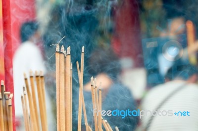Incense Stick Burning Slowly With Fragrant Smell Smoke. People Praying On Chinese Buddhist Temple On Chinese New Year, Luna New Year Stock Photo