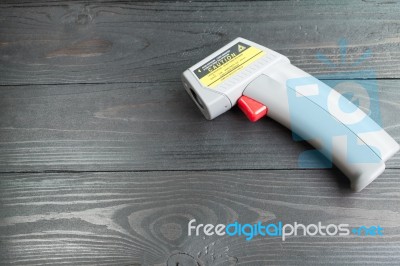 Infrared Thermometer On Wooden Background Stock Photo