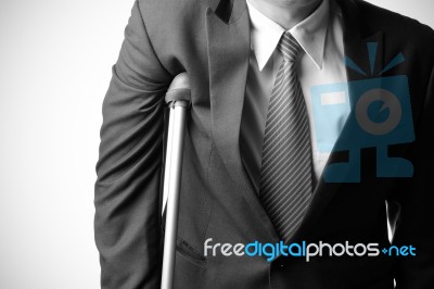 Injured Businessman With Crutches, Insurance Concept Stock Photo