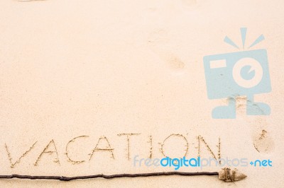 Inscription Of Vacation Written On Wet Yellow Beach Sand With Fo… Stock Photo
