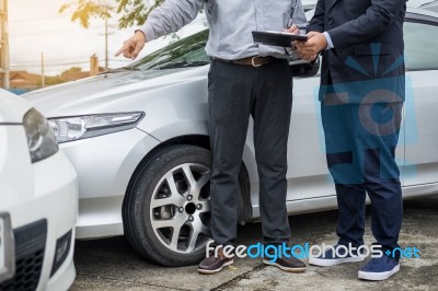 Insurance Agent Writing On Clipboard While Examining Car After A… Stock Photo