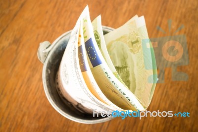 International Currencies Bank Note In The Bucket Stock Photo