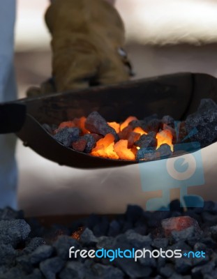Iron Smith Working Near Hot Coal Stock Photo