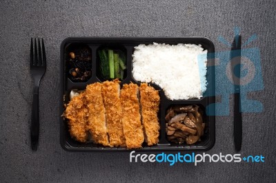 Japanese Food Tonkatsu Rice And Vegetable Take Away On Table Background Stock Photo