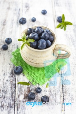 Jug Of Blueberries On White Wooden Table Stock Photo