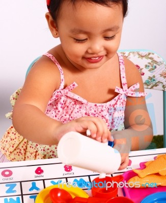 Kid Playing At Pouring Cup Of Tea Stock Photo