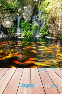Koi Fish In Pond At The Garden With A Waterfall And Wood Walkway… Stock Photo