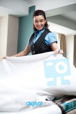 Lady Attendant Arranging Bed Sheet Stock Photo