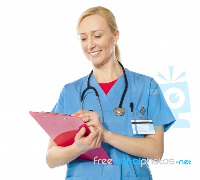 Lady Doctor Writing On Clipboard Stock Photo