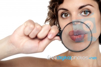 Lady Holding Magnifying Glass In Front Of Her Lips Stock Photo