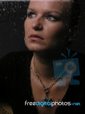 Lady Looking Through A Rainy Window Stock Photo