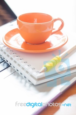 Laptop With Coffee Cup And Notepad On Desk Stock Photo