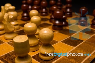 Light And Dark Wooden Chess Pieces On Chess Table Stock Photo