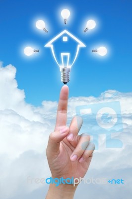 Light Bulb Model Of House In Hand Stock Photo