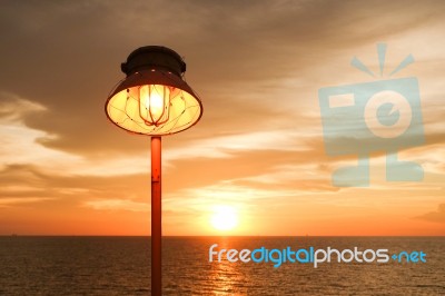 Lighting Of Warm Lamp And Lighting Of Sunset At Sea Stock Photo