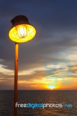 Lighting Of Warm Lamp And Lighting Of Sunset At Sea Stock Photo