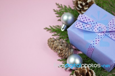 Lilac Gift With Polka Dot Ribbon With Christmas Decoration On Pink Background Stock Photo