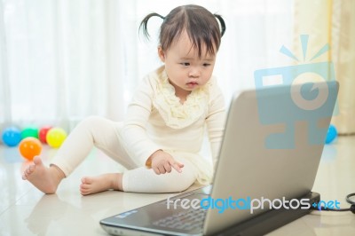 Little Asian Girl Play Laptop In Home Stock Photo
