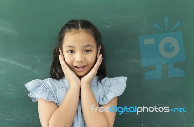 Little Asian Girl With Hands Close To Face Smiling Looking At Camera Stock Photo