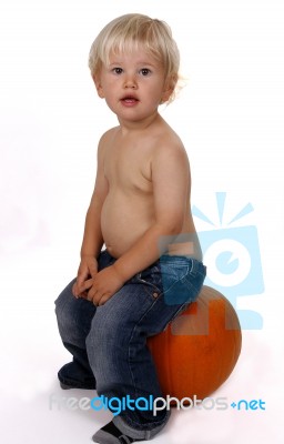 Little Boy On A Pumpkin Stock Photo