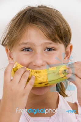Little Girl Eating Banana Stock Photo