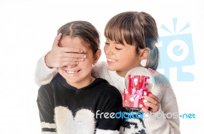 Little Girl Giving Surprise Love Gift To Her Friend With White Background Stock Photo
