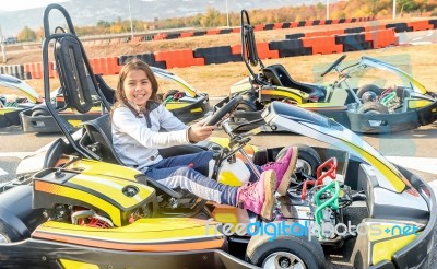 Little Girl Is Driving Go- Kart Car In A Playground Racing Track… Stock Photo