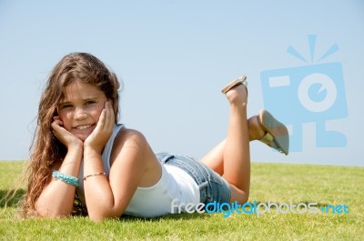 Little Girl lying with cupping face Stock Photo