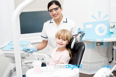 Little Girl Sitting In Dental Clinic Stock Photo